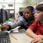 Two students work together at a computer in a classroom