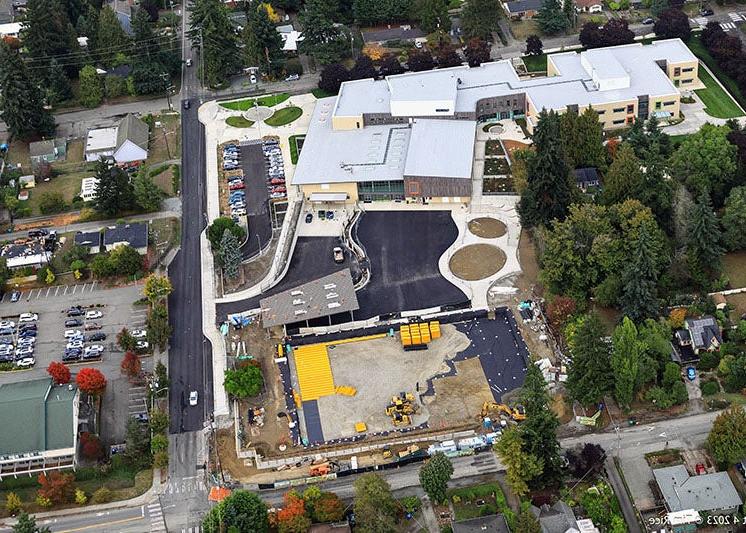 aerial view of a large building and paved areas with some construction work taking place in the lower portion